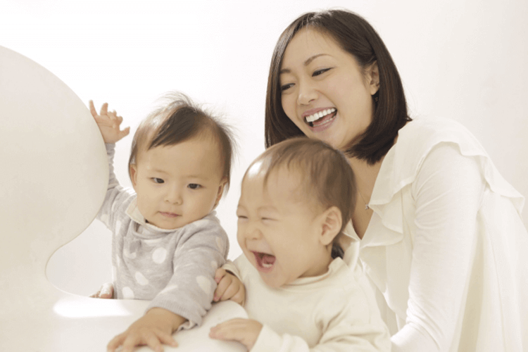 満面の笑みを浮かべる母親と、楽しそうに笑う二人の幼い子供たち